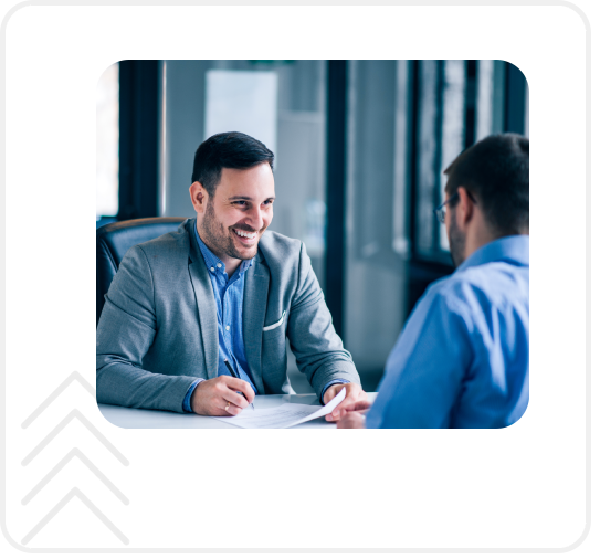 Two people sitting at a table talking to each other.