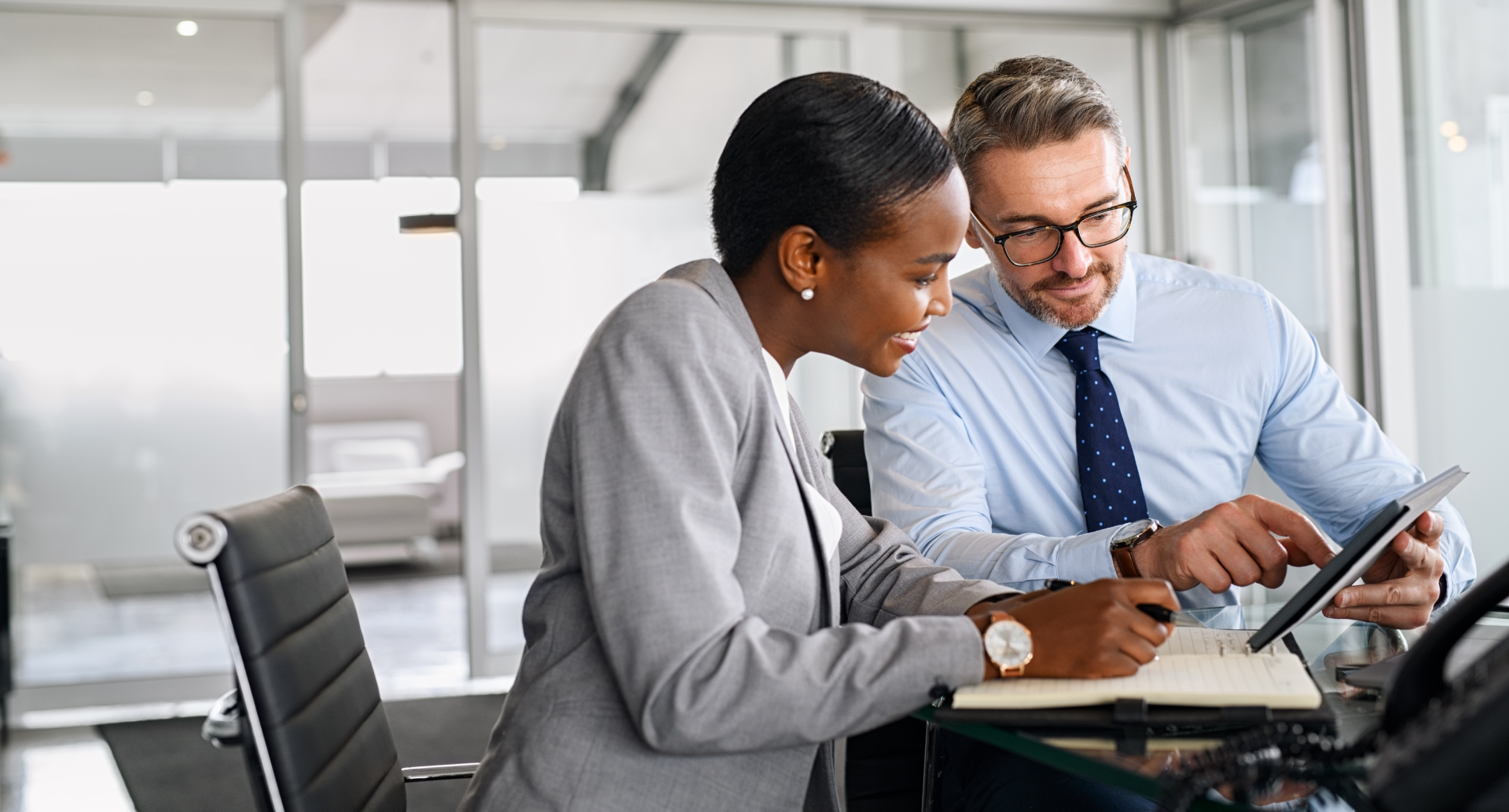 A woman and man looking at something on a tablet.