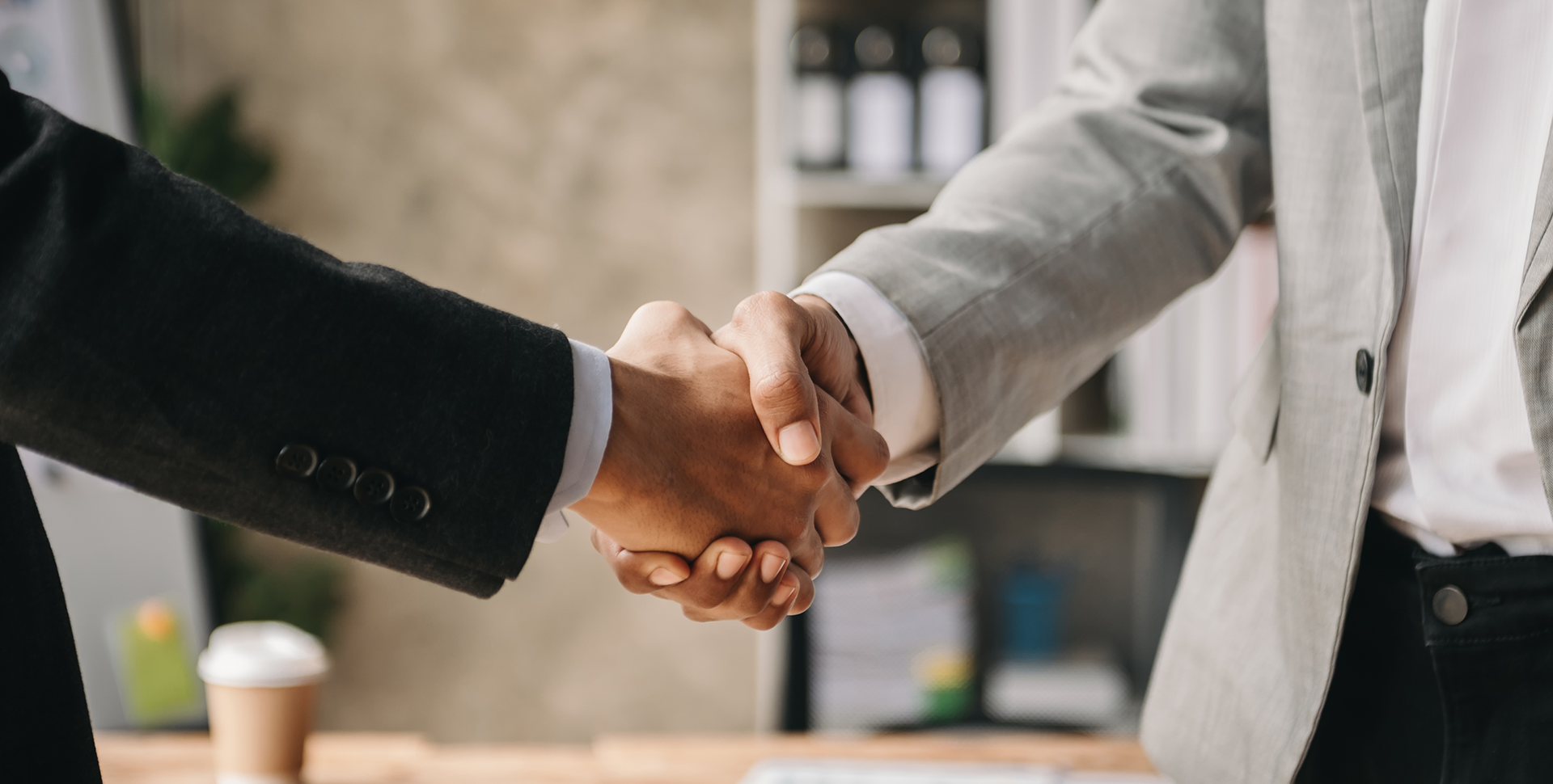 Two people shaking hands in a room.